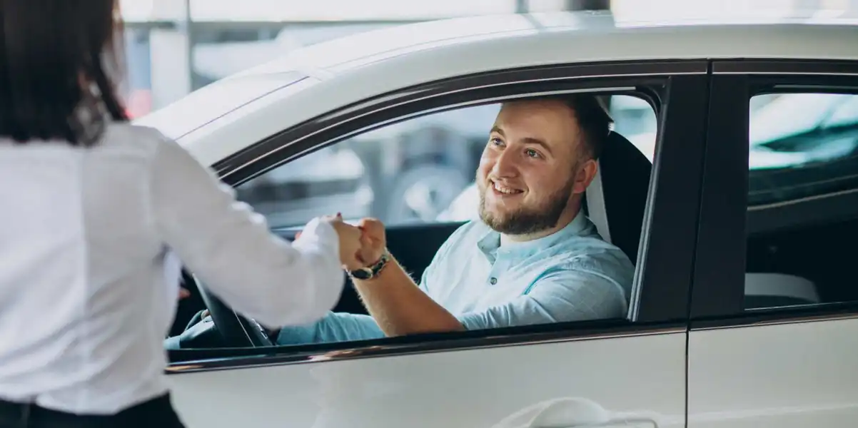 a man receives the keys for a car rental